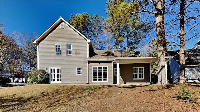 back of house with a lawn and french doors