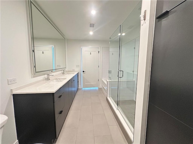 full bath featuring double vanity, visible vents, tile patterned flooring, a stall shower, and a sink