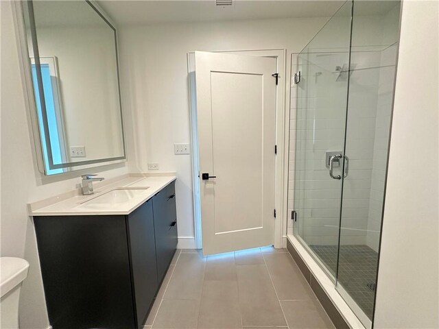 bathroom with vanity, tile patterned floors, a stall shower, and toilet