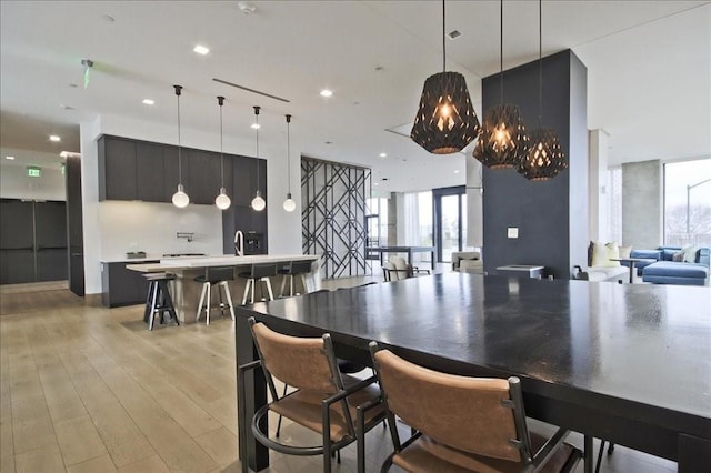 dining room featuring recessed lighting, expansive windows, and light wood-style floors