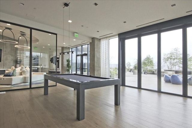 rec room featuring wood finished floors, pool table, and a wall of windows