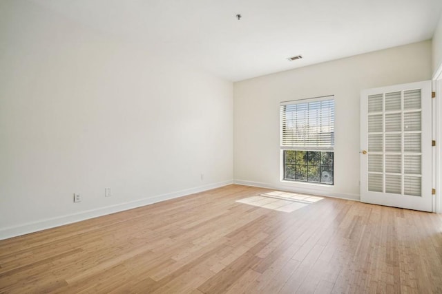 unfurnished room featuring light wood-style floors, baseboards, and visible vents