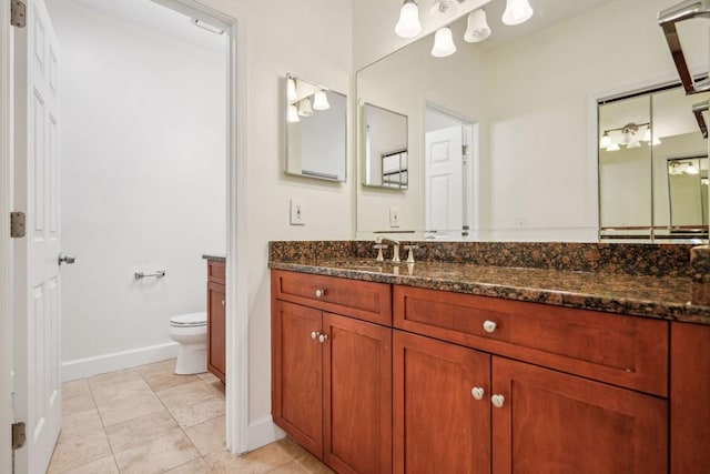 bathroom with vanity, tile patterned flooring, toilet, and baseboards