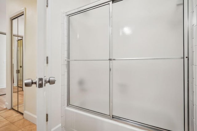 full bath with shower / bath combination with glass door and tile patterned floors