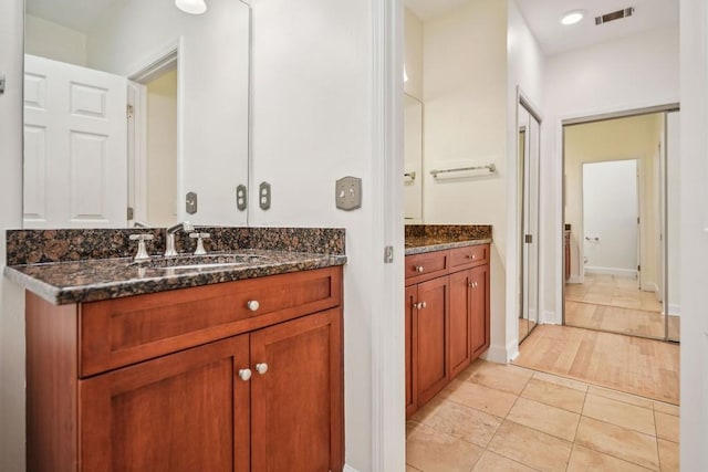 bathroom featuring tile patterned flooring, visible vents, baseboards, and vanity