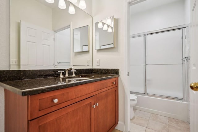 full bath with enclosed tub / shower combo, vanity, toilet, and tile patterned floors