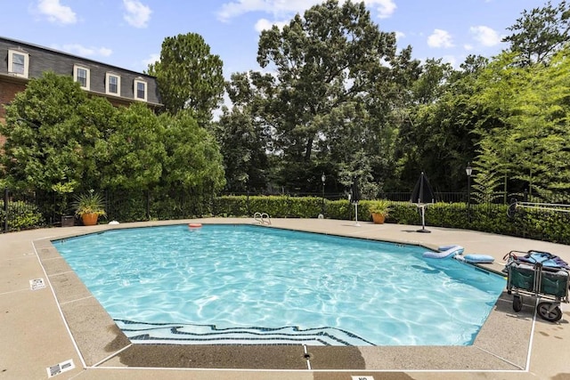 pool with a patio and fence