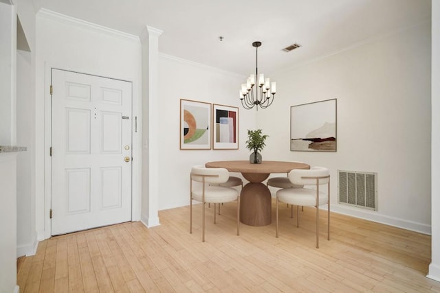 dining room featuring light wood-type flooring, visible vents, a notable chandelier, and ornamental molding