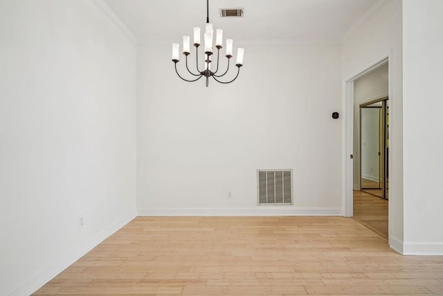 spare room featuring light wood-style floors, visible vents, and crown molding