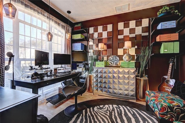 office space featuring visible vents, a textured ceiling, and wood finished floors