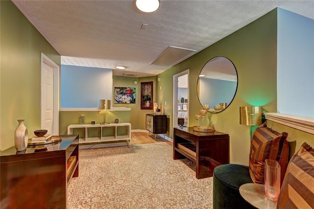 sitting room with a textured ceiling and wood finished floors