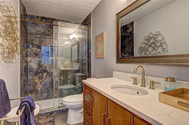 bathroom with a shower stall, a textured ceiling, vanity, and toilet