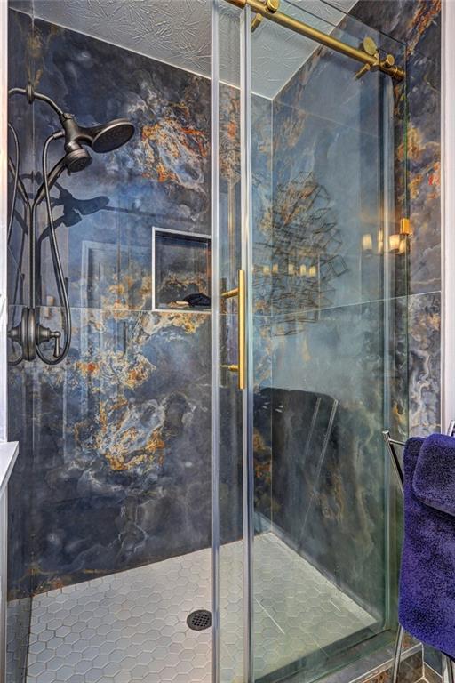 full bathroom featuring a marble finish shower