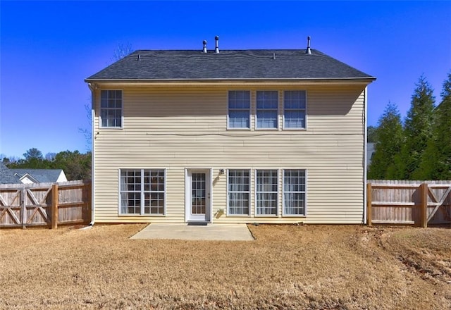 rear view of property with a patio area, fence, and a shingled roof