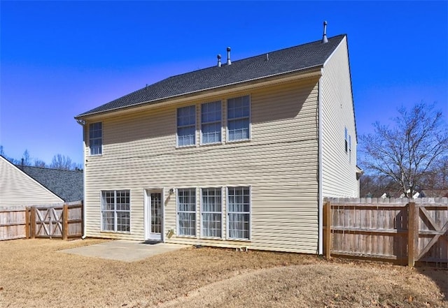 rear view of house featuring a fenced backyard and a patio area