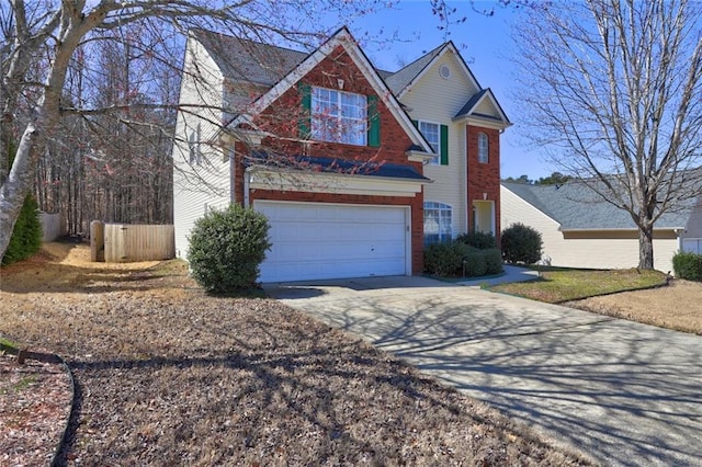 traditional-style house with brick siding, an attached garage, concrete driveway, and fence