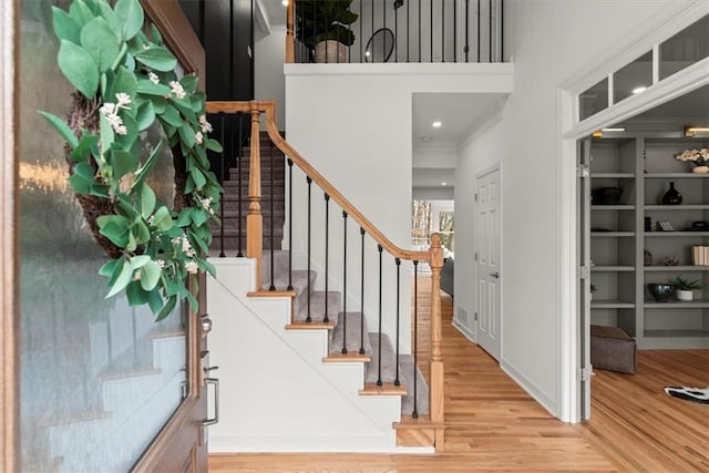 interior space featuring a towering ceiling and wood-type flooring