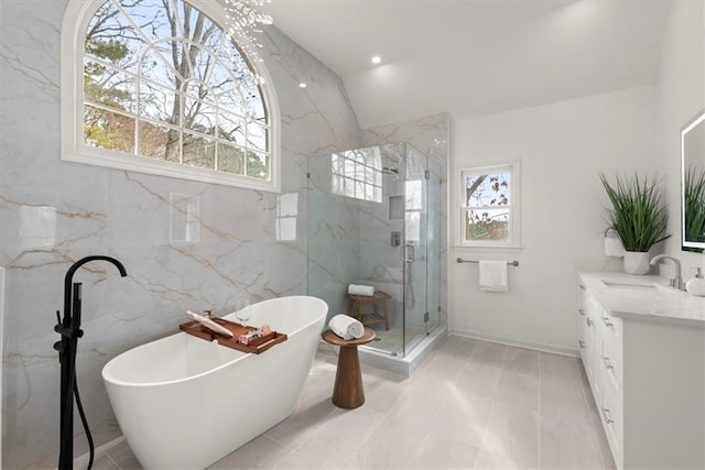 bathroom featuring vanity, independent shower and bath, and tile walls