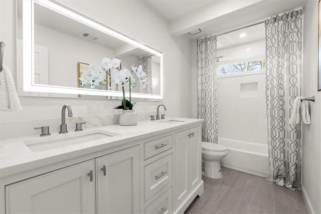 full bathroom with vanity, hardwood / wood-style floors, toilet, and shower / bath combo