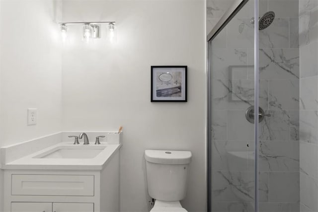 bathroom featuring vanity, a shower with shower door, and toilet