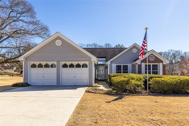 ranch-style house featuring a garage, concrete driveway, and brick siding