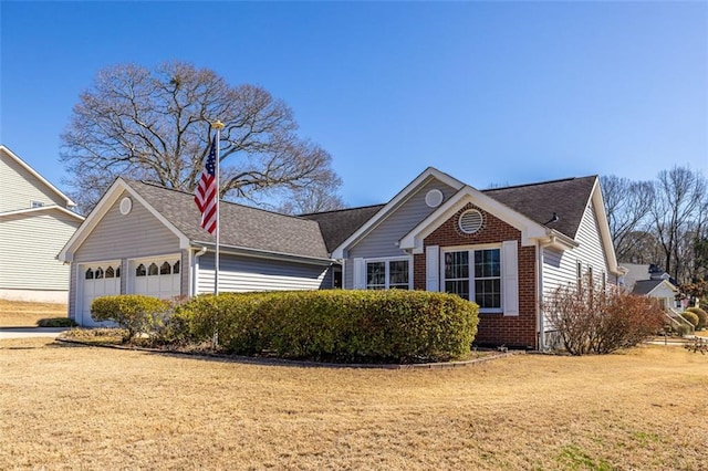 ranch-style house with an attached garage, a front lawn, and brick siding