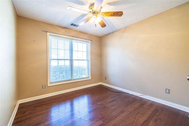 empty room featuring baseboards, visible vents, ceiling fan, dark wood-style flooring, and a textured ceiling