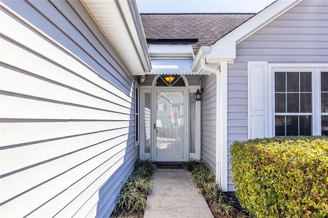 property entrance featuring a shingled roof