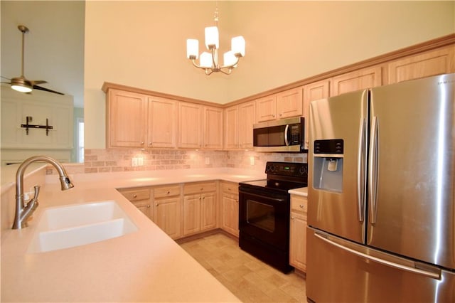 179 Camry Ln, Grayson, GA 30017 - kitchen with appliances with stainless steel finishes, light brown cabinets, a sink, a chandelier, and a high ceiling
