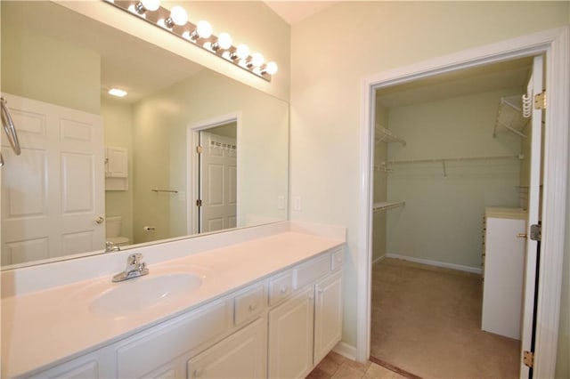 179 Camry Ln, Grayson, GA 30017 - bathroom featuring vanity, toilet, a spacious closet, and baseboards