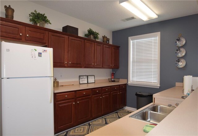 179 Camry Ln, Grayson, GA 30017 - kitchen featuring freestanding refrigerator, a sink, light countertops, and a textured ceiling
