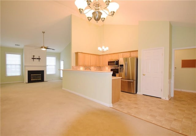 179 Camry Ln, Grayson, GA 30017 - kitchen featuring stainless steel appliances, a chandelier, high vaulted ceiling, baseboards, and a glass covered fireplace