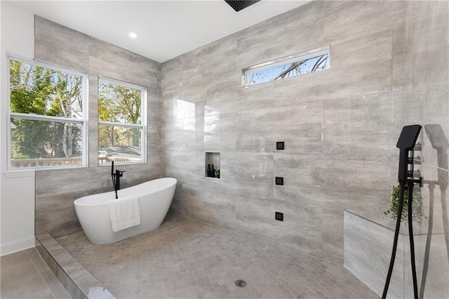 60 Newcastle St SW, Atlanta, GA 30314 - bathroom with a freestanding tub, tile patterned floors, a tile shower, and tile walls
