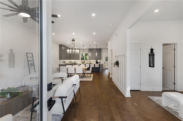 hallway with dark hardwood / wood-style flooring and a notable chandelier