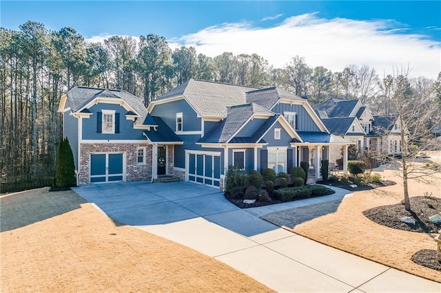 craftsman house with concrete driveway, a garage, brick siding, and board and batten siding