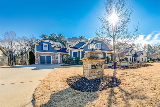 craftsman-style home with driveway, a garage, and a residential view