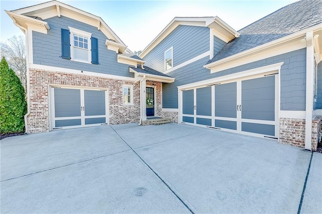 view of front of property with driveway, brick siding, and an attached garage