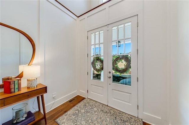 doorway to outside featuring french doors, wood finished floors, and baseboards