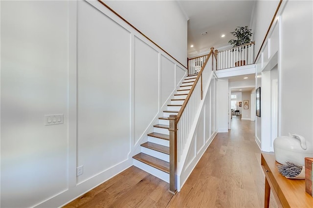 staircase featuring wood finished floors and recessed lighting