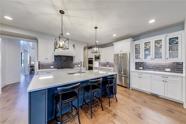 kitchen featuring stainless steel appliances, a sink, white cabinets, decorative backsplash, and recessed lighting
