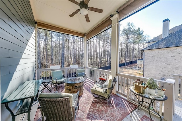 sunroom / solarium with a fire pit, ceiling fan, and plenty of natural light