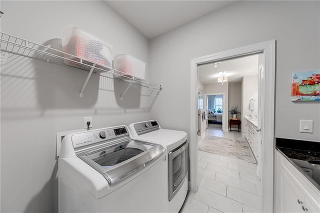 clothes washing area featuring washer and dryer and light tile patterned floors
