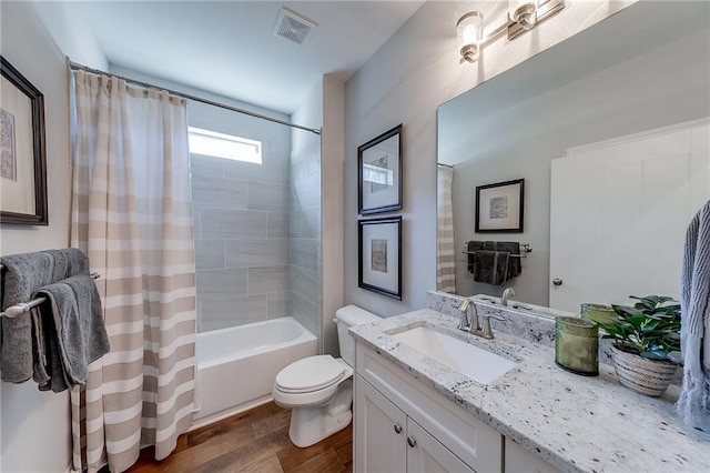 bathroom with wood finished floors, toilet, vanity, and shower / bath combination with curtain