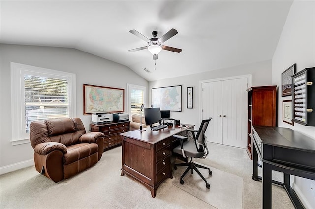 home office with a ceiling fan, vaulted ceiling, light colored carpet, and baseboards