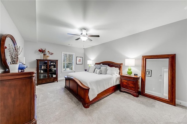 bedroom featuring light colored carpet, baseboards, and ceiling fan