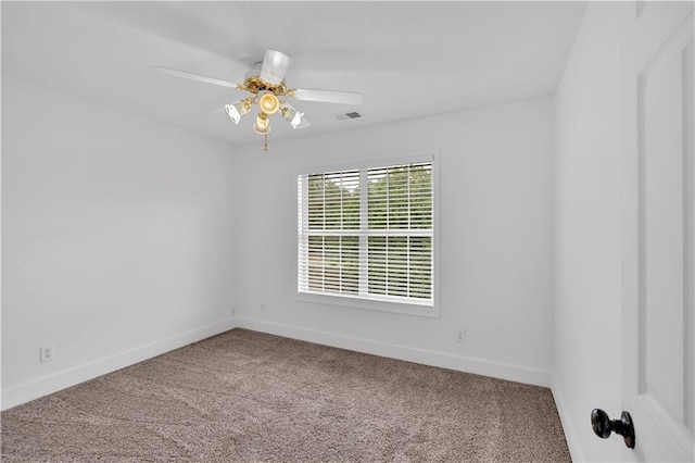 carpeted spare room featuring baseboards and ceiling fan