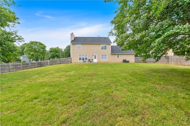 back of property with a chimney and central AC