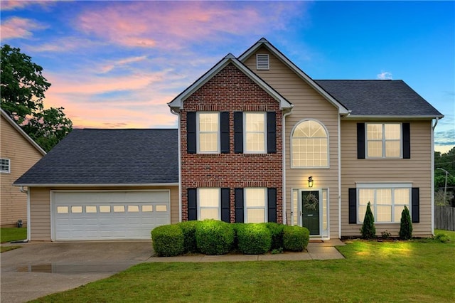 view of front of home with concrete driveway, a front yard, a garage, and roof with shingles