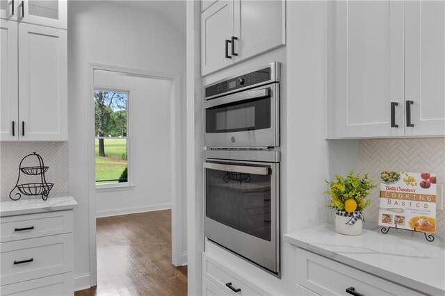 1217 Cabin Bridge Rd, Bethlehem, GA 30620 - kitchen with stainless steel double oven, backsplash, and white cabinetry