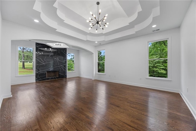 1217 Cabin Bridge Rd, Bethlehem, GA 30620 - unfurnished living room featuring arched walkways, a chandelier, a raised ceiling, wood finished floors, and recessed lighting